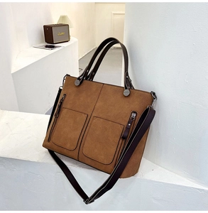 Close-up of brown suede tote bag with double pockets and vintage hardware details