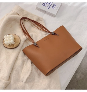 Gros plan du sac cabas en cuir marron avec logo FASHION sur veste en polaire
