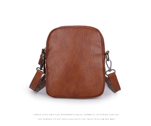Detail shot of vintage brown leather texture and metal buckle on the crossbody phone bag