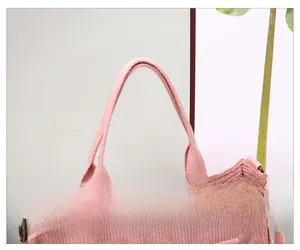 Detail of pink corduroy handbag featuring sturdy handles and vintage metal buckle closure