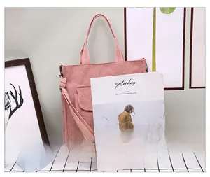 Pink corduroy tote bag shown next to a magazine to demonstrate large storage capacity