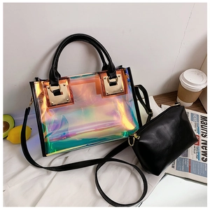 Detail of holographic PVC tote bag and black inner pouch on aesthetic wooden desktop