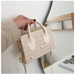 Gros plan du sac fourre-tout en paille avec broderie marguerite et bandoulière en similicuir