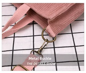 Detailed close-up of bronze metal lobster clasp and pink corduroy fabric on handbag strap