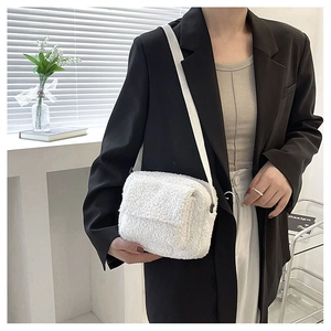 Détail du sac bandoulière blanc en peluche montrant la texture en laine et le rabat