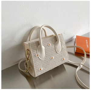 Détail du sac cabas en paille avec broderie marguerite délicate et anses en cuir