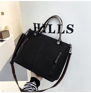 Detail of matte black tote bag with dual zip pockets and vintage silver hardware
