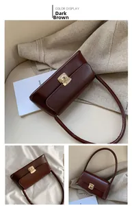 Close-up of a vintage dark brown shoulder bag with a polished gold metallic clasp