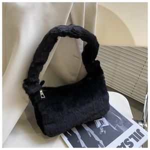 Détail d'un sac à main noir en peluche avec fermeture éclair et texture fausse fourrure