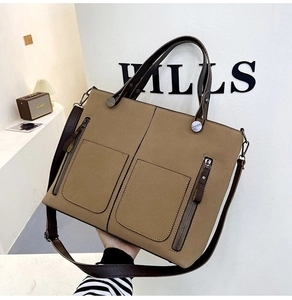 Detail of khaki frosted leather tote bag showing double pockets and tassel zippers