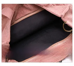 Detail view of pink corduroy tote bag showing zipper pocket and bronze metal ring