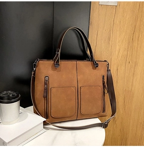 Detail view of a brown vintage tote bag with dual front pockets and adjustable shoulder strap