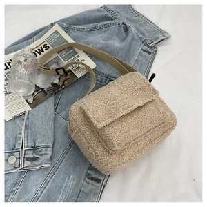 Détail du sac bandoulière en polaire beige avec sangle tissée et rabat de style automne