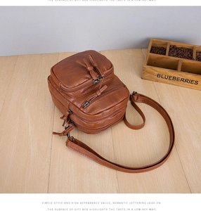 Detail view of brown multi-layer zipper crossbody bag with textured lychee pattern PU leather