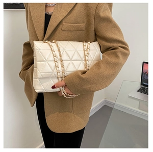 Mannequin portant un sac bandoulière en cuir PU crème avec matelassage triangulaire et chaîne