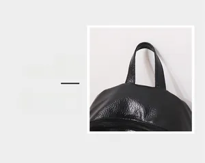 Detail magnification of the black leather backpack featuring a sturdy and comfortable handle