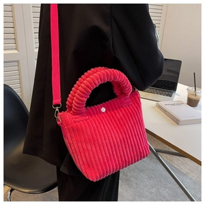 Detailed view of rose red corduroy bucket bag texture with shoulder strap and button