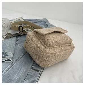 Détail du sac en peluche beige avec une bandoulière en toile réglable pratique