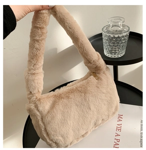 Gros plan sur la texture en fausse fourrure crème et le zip doré du sac à main