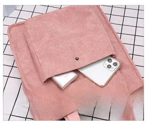 Pink corduroy crossbody bag detail showing front pocket with snap and phone storage