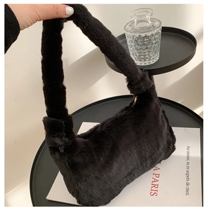 Détail de la texture pelucheuse noire et de l'anse intégrée de ce sac à main en fourrure