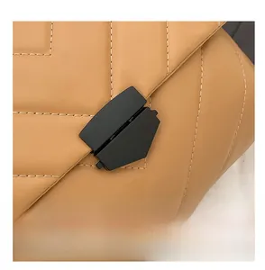 Detail shot of camel quilted leather crossbody bag with matte black hardware and lock