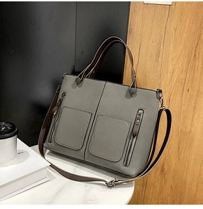 Detail of grey nubuck tote bag with dual front pockets and brown contrast straps