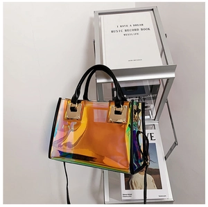 Detail of laser iridescent PVC tote with black leather handles and gold metal buckles
