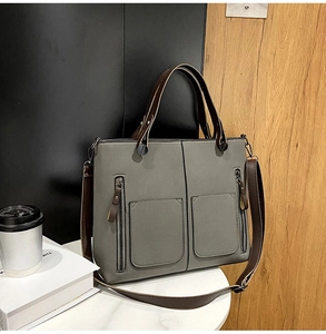 Macro detail of matte grey faux leather texture and dual front zipper pockets