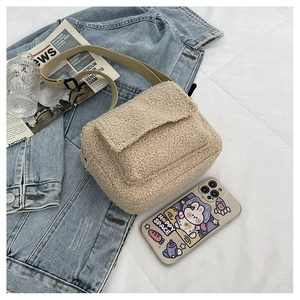 Détail du sac bandoulière beige en laine bouclée avec texture et sangle réglable