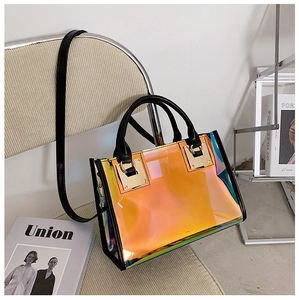 Detail of holographic tote bag with black handles and gold hardware on a beige chair