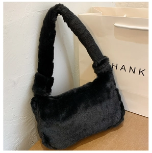 Détail de la texture en fausse fourrure noire douce sur le sac sous le bras en peluche