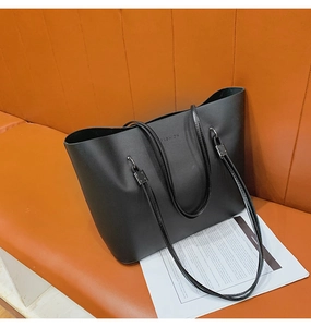 Détails de la gravure fashion et des boucles métalliques sur le sac cabas en cuir noir
