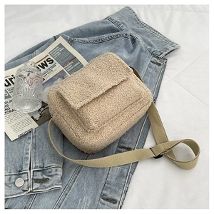 Gros plan sur le sac bandoulière beige en peau de mouton avec bandoulière réglable
