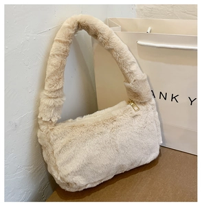Détail d'un sac sous les aisselles en fausse fourrure beige avec fermeture éclair dorée