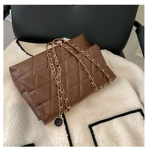 Détail d'un sac à main marron foncé en similicuir matelassé avec chaîne dorée