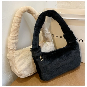 Vue détaillée des sacs sous les bras en peluche beige et noir avec fermeture éclair dorée
