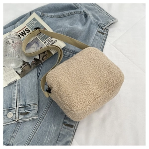 Détail du sac bandoulière beige en laine d'agneau avec large sangle sur denim