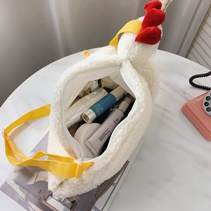 Cute plush chicken-shaped crossbody bag with red comb and yellow strap on marble surface