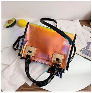 Detailed macro of holographic PVC handbag featuring black handles and gold hardware