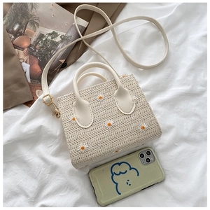 Détail du sac cabas en paille avec broderie marguerite et bandoulière amovible