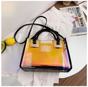 Detail of holographic transparent tote bag with black faux leather straps and gold metal studs