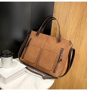 Detail of vintage matte leather tote bag with functional double front vertical zippers