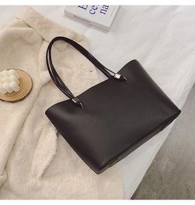 Détail d'un grand sac cabas noir avec texture cuir élégante et boucles en métal argenté