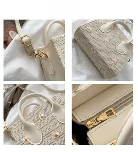 Détails de broderie de marguerites sur sac en paille beige avec poignée en cuir chic