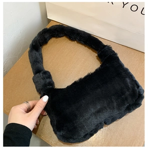 Gros plan sur la texture douce en fausse fourrure noire d'un sac à main minimaliste