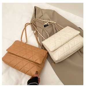 Détail de sacs à rabat en cuir PU matelassé avec chaînes dorées en coloris caramel et crème