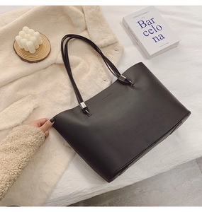Détail du sac cabas noir avec texture mate, gaufrage mode et longues bandoulières