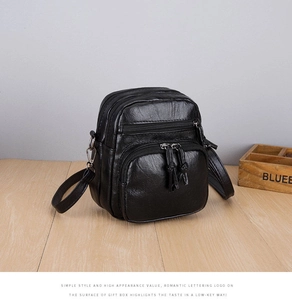Detail view of black PU leather crossbody bag with multiple silver zipper pockets