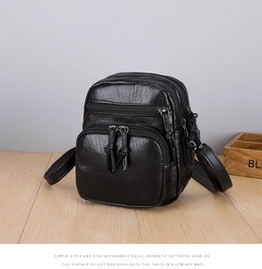 Detail of vintage black PU crossbody bag with multi-zipper pockets and tassel sliders